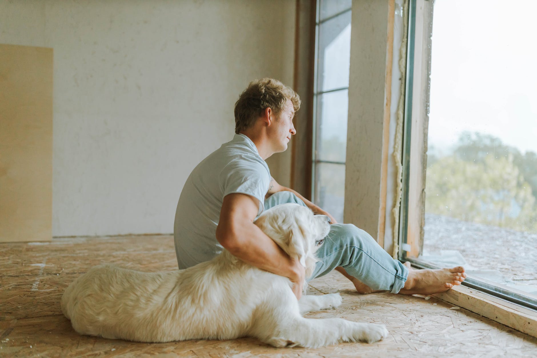 a man sitting beside his pet