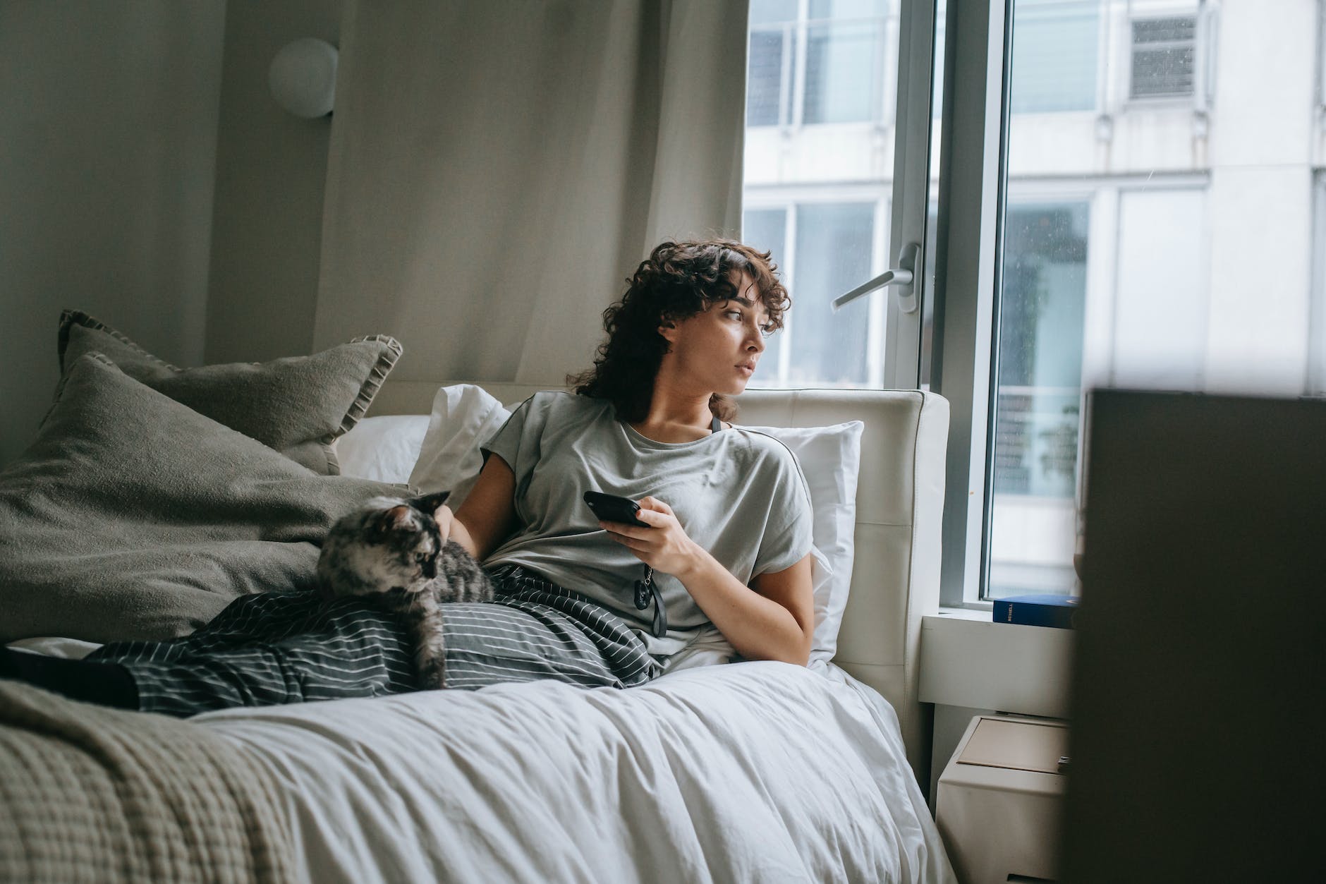 calm woman with cat in bedroom